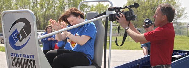 videographer records student's reaction on the seat belt convincer